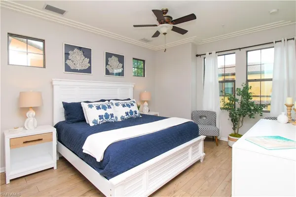 a bedroom with a large bed and a chandelier fan