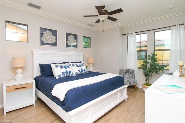 a bedroom with a large bed and a chandelier fan