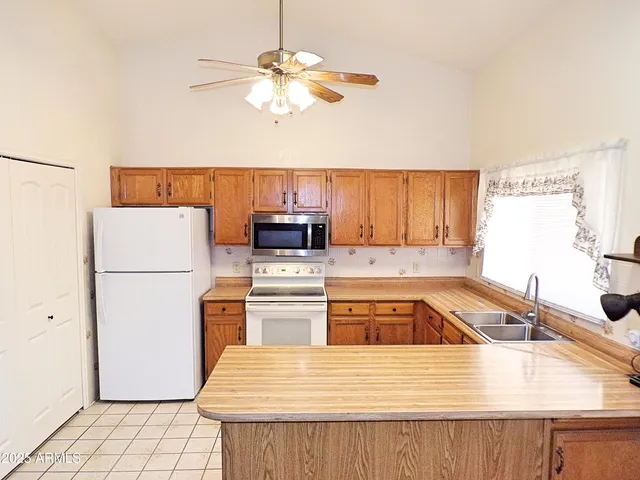a kitchen with a refrigerator a stove a sink and dishwasher with wooden floor