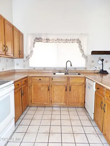 a kitchen with a sink a stove top oven and cabinets