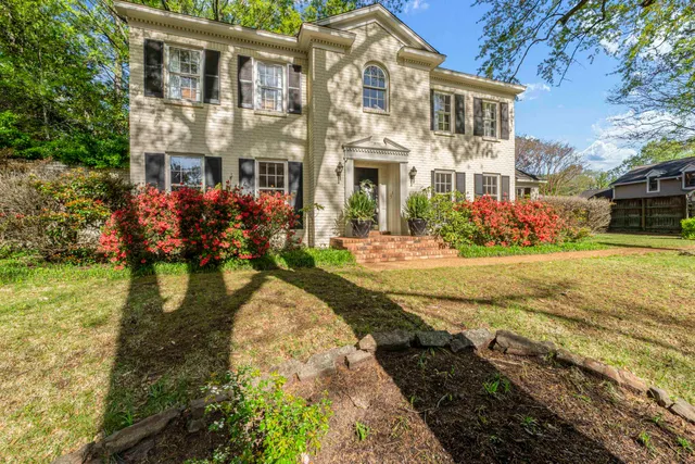 a view of house with outdoor space and garden
