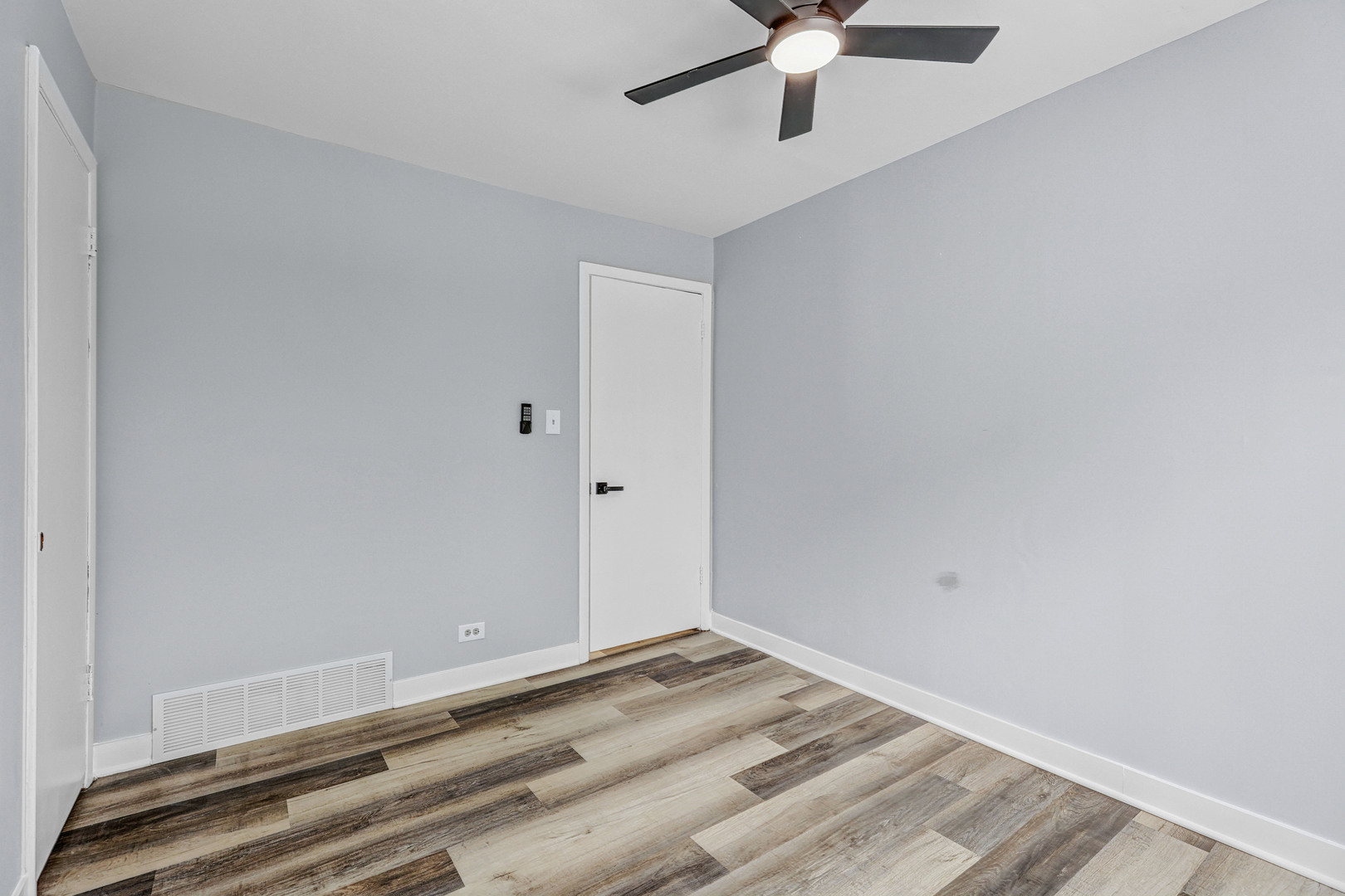 7001 Meadow Lane Road Long Grove, IL 60060 - Photo 19 of 48 an empty room with a ceiling fan and wooden floor