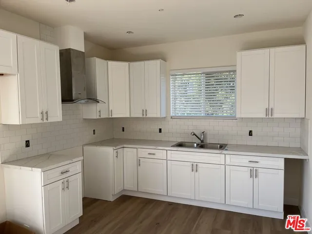 a kitchen with white cabinets sink and dishwasher