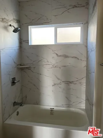 a bathroom with a bathtub and shower