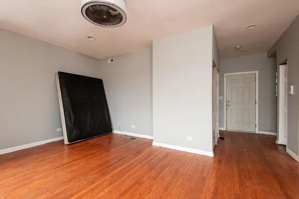 a view of empty room with wooden floor