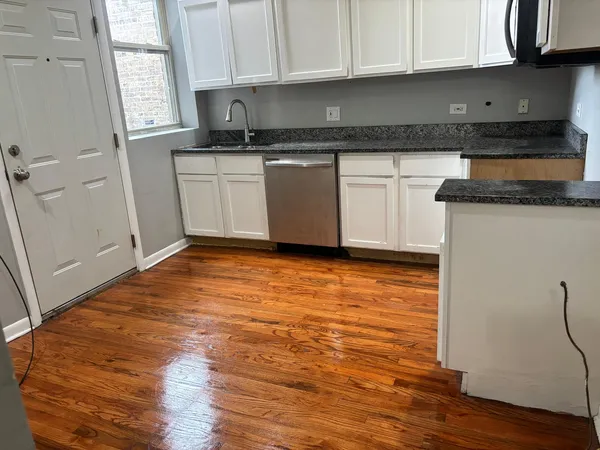 a kitchen with granite countertop a stove a sink and a refrigerator