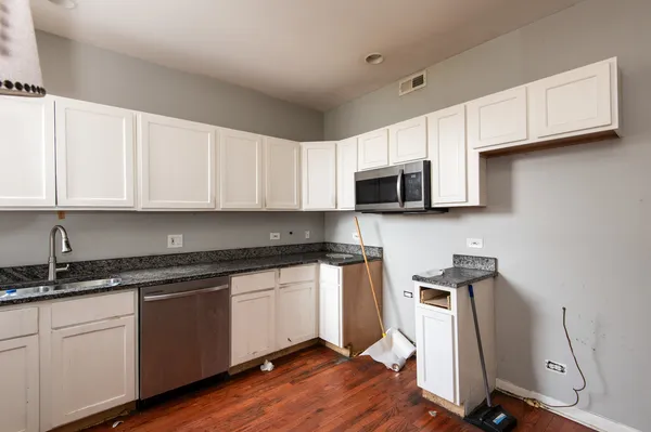 a kitchen with stainless steel appliances granite countertop a sink a stove a microwave and cabinets