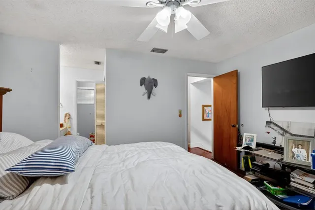 a bedroom with a bed and a flat tv screen on a dresser