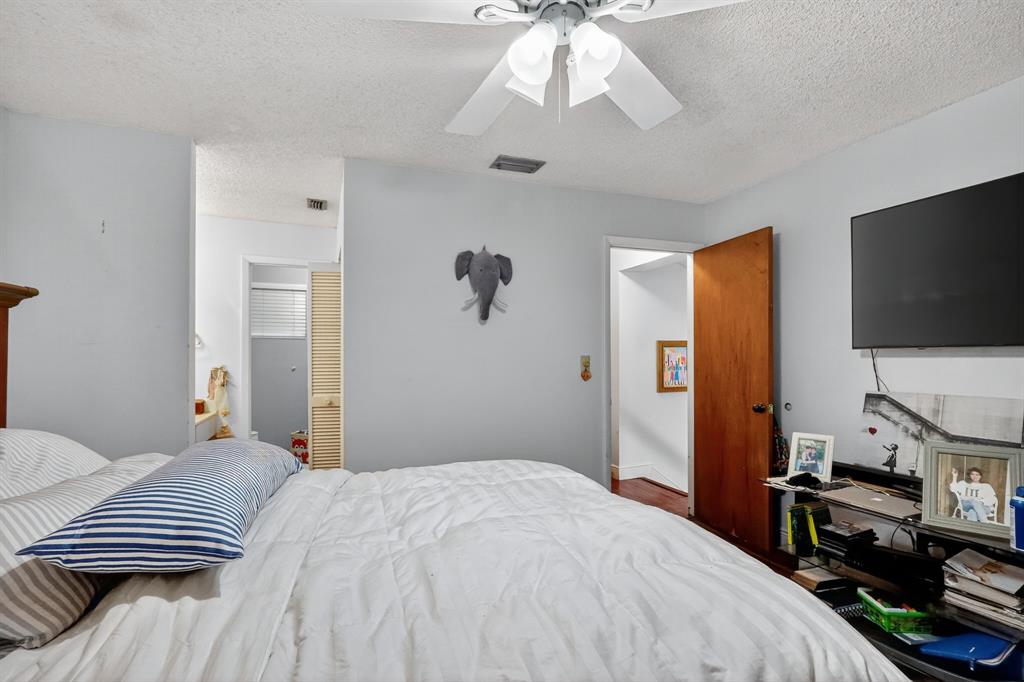 13501 Southwest 62nd Street, Unit 1 Miami, FL 33183 - Photo 13 of 38 a bedroom with a bed and a flat tv screen on a dresser