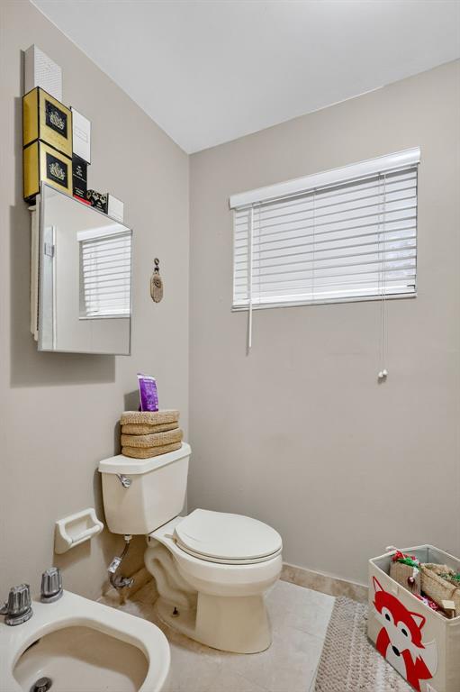 13501 Southwest 62nd Street, Unit 1 Miami, FL 33183 - Photo 16 of 38 a bathroom with a toilet sink and mirror