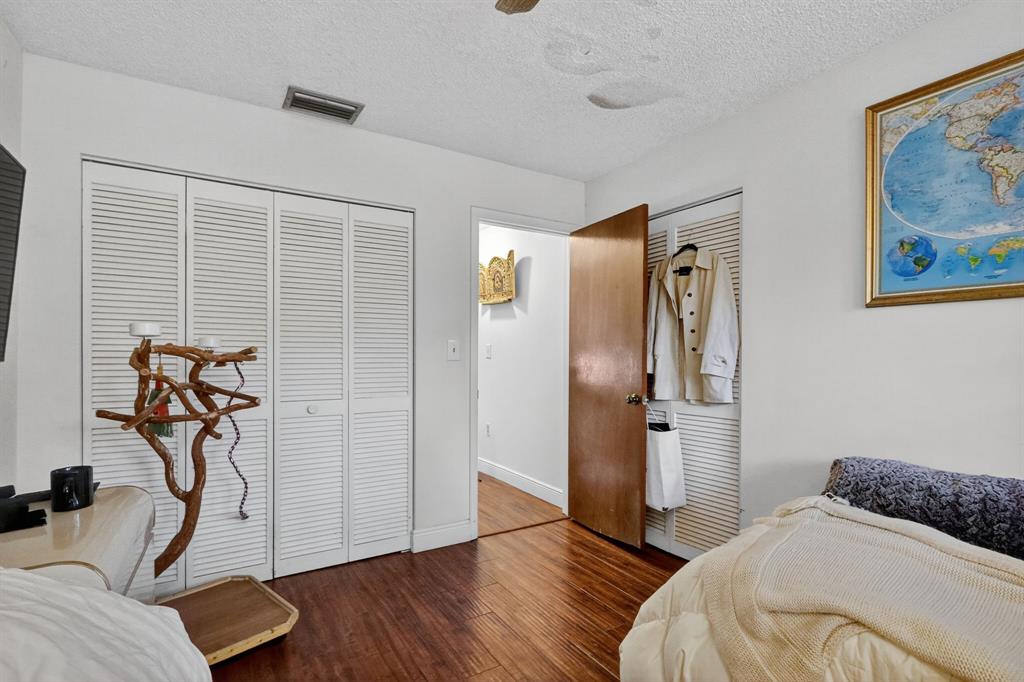 13501 Southwest 62nd Street, Unit 1 Miami, FL 33183 - Photo 18 of 38 a bedroom with a bed and wooden floor