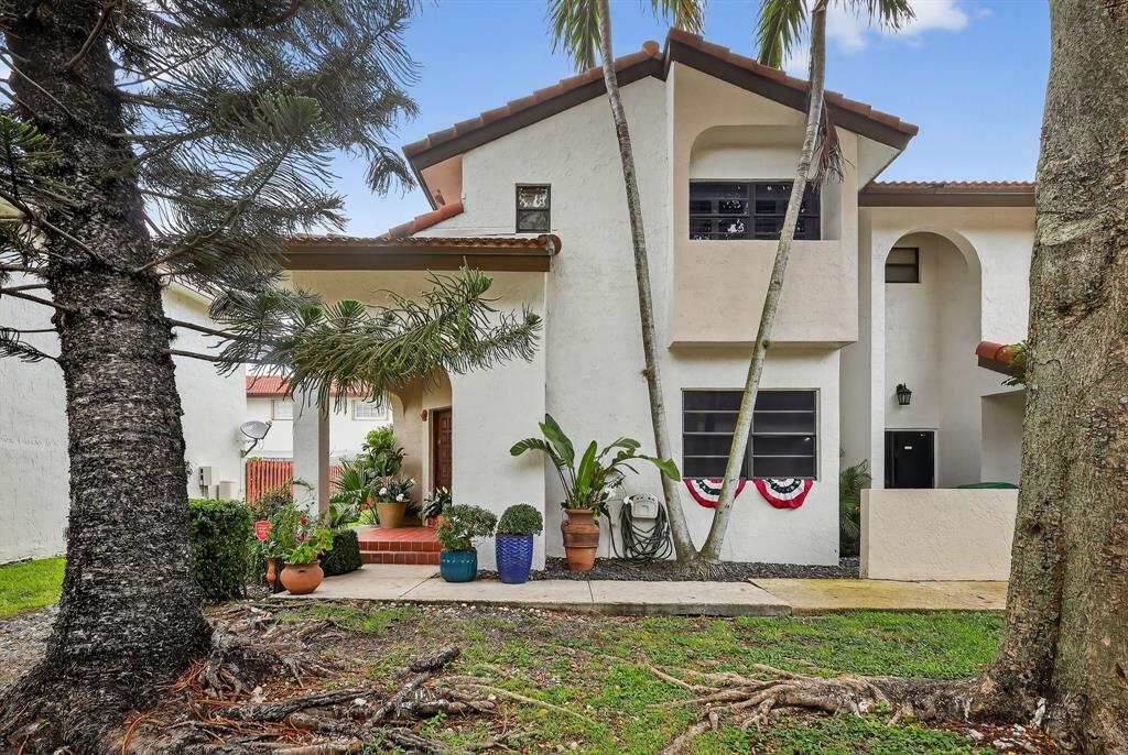 13501 Southwest 62nd Street, Unit 1 Miami, FL 33183 - Photo 26 of 38 a view of a white house with potted plants and a large tree