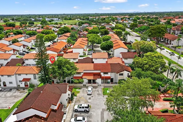 an aerial view of residential houses with outdoor space and trees