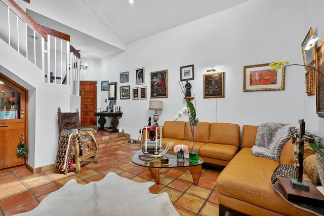 a living room with furniture a couch and paintings on the wall