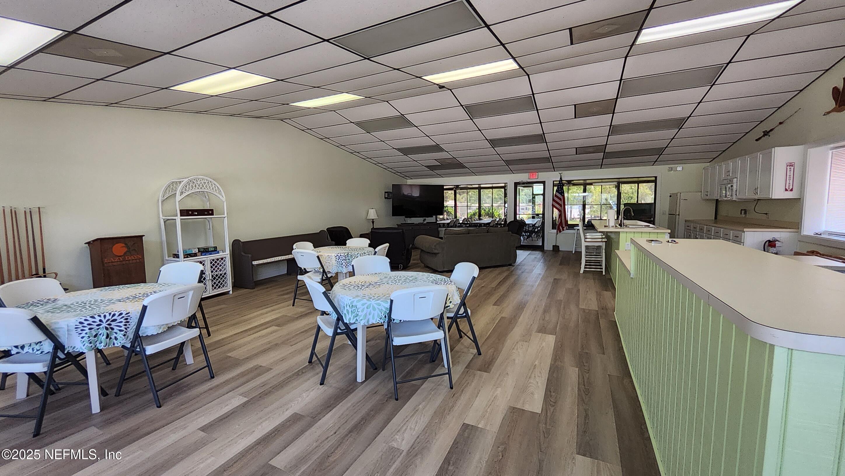 1074 Front Street, Unit 50B Welaka, FL 32193 - Photo 17 of 20 a dining room with furniture a rug a potted plant and a wooden floor