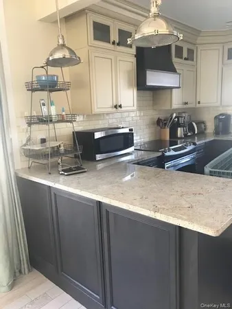 a kitchen with stainless steel appliances granite countertop a sink a stove and a microwave