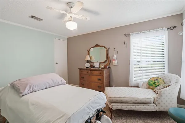 a bedroom with a bed and dresser with mirror