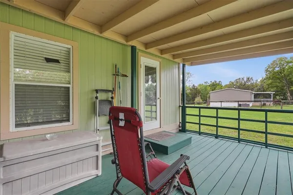 a view of a porch with furniture and a yard