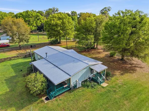 an aerial view of a house with yard and outdoor seating