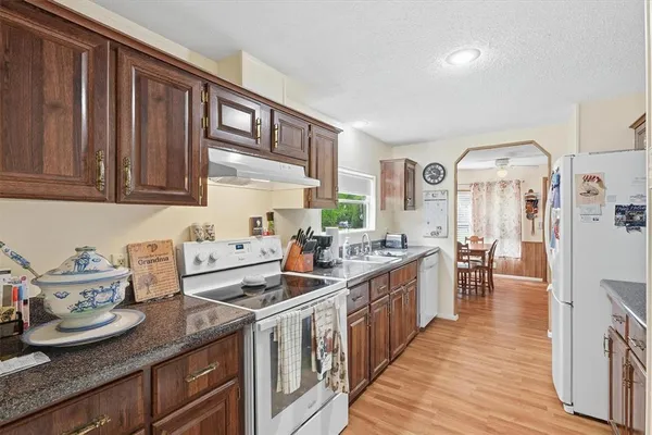 a kitchen with stainless steel appliances granite countertop a lot of counter space and wooden floors