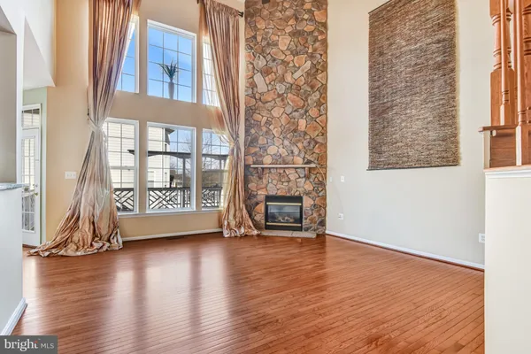a view of a big room with wooden floor and a kitchen