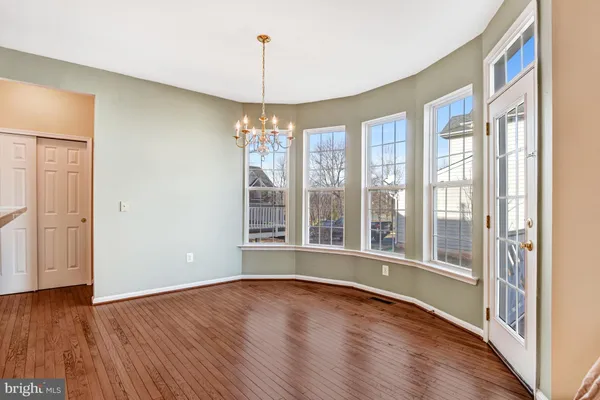 a kitchen with stainless steel appliances granite countertop a stove top oven a refrigerator a sink and dishwasher with wooden floor