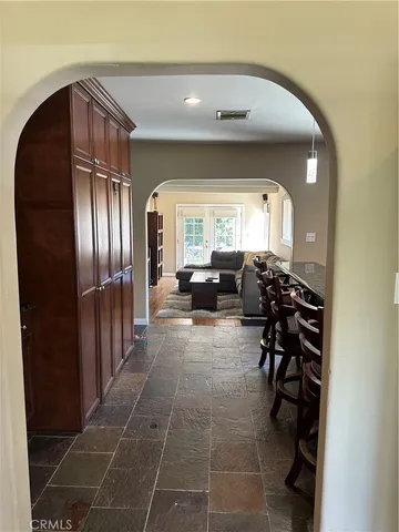 a living room with furniture a large mirror and a glass door