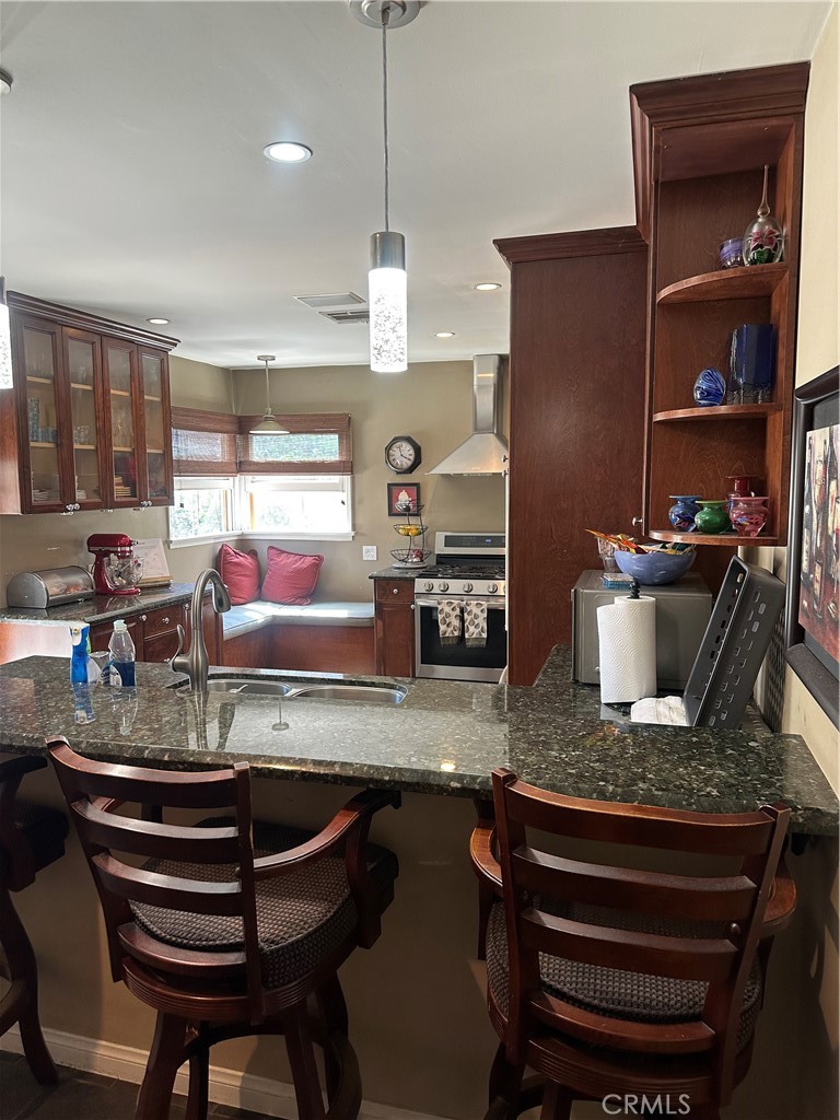 4910 Willowcrest Avenue Toluca Lake, CA 91601 - Photo 13 of 25 a kitchen with a stove a refrigerator and a wooden cabinets