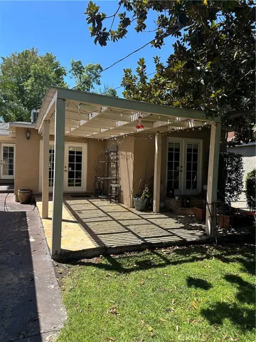 a view of house with yard furniture and outdoor kitchen