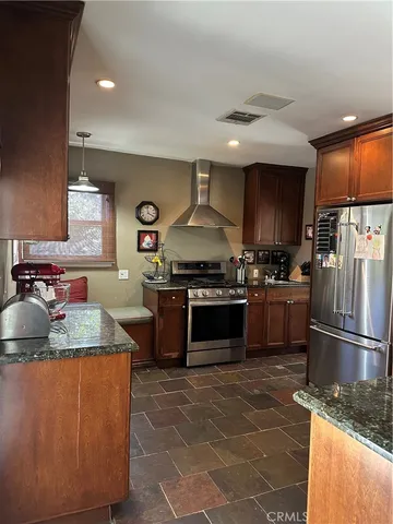 a kitchen with stainless steel appliances granite countertop a stove a sink and a refrigerator