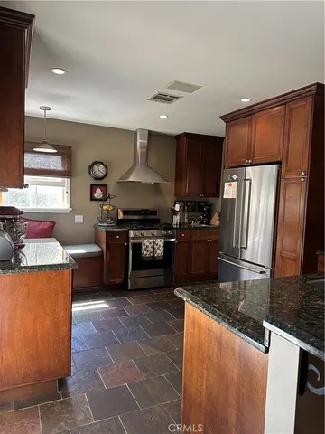 a kitchen with stainless steel appliances granite countertop a stove a sink and a refrigerator