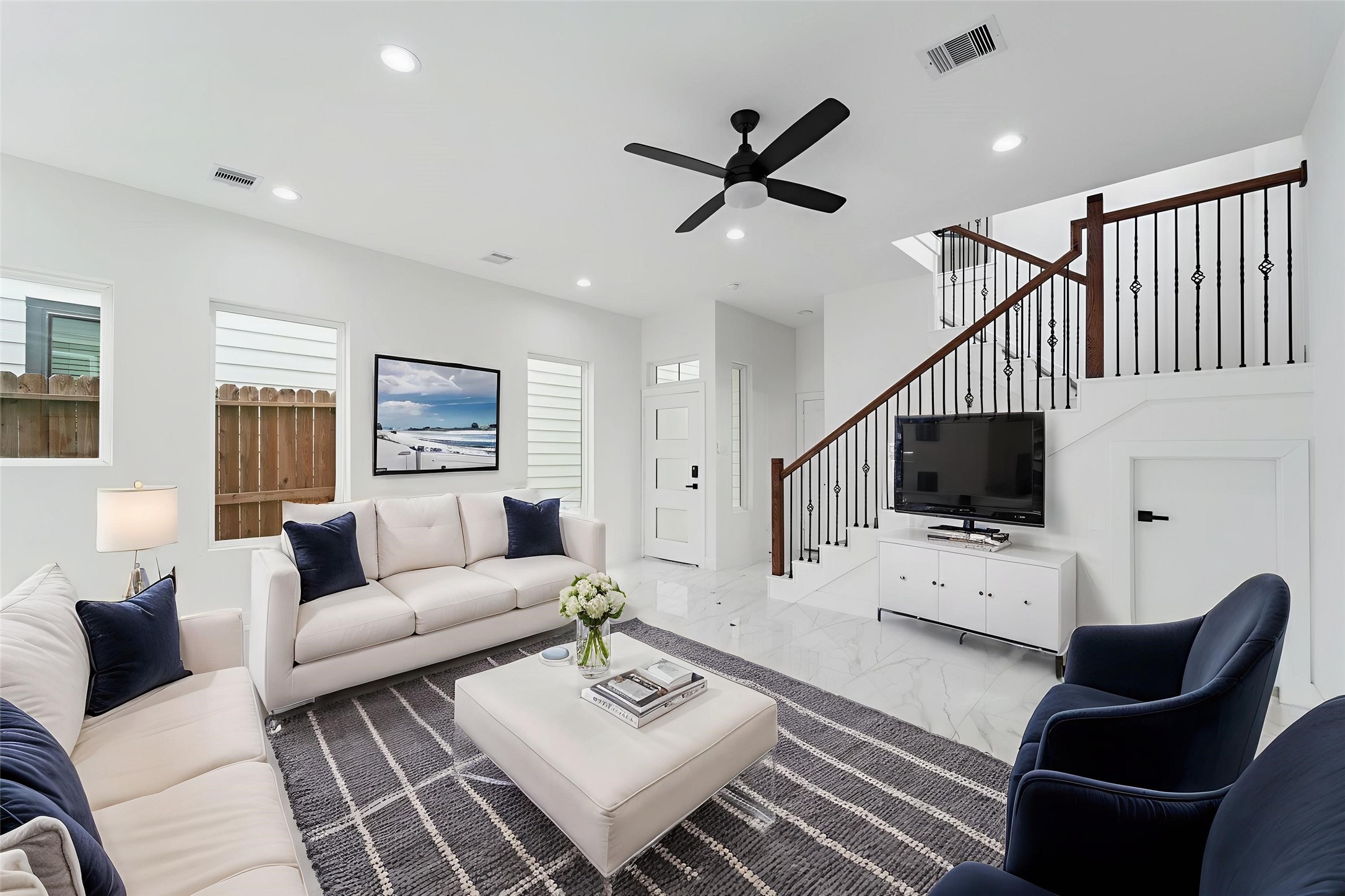 7709 Willow Street Houston, TX 77088 - Photo 9 of 15 The main living area features high white walls, recessed lighting, and a modern black ceiling fan above the space.