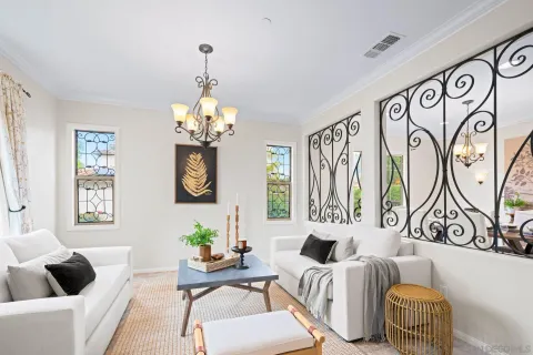 a view of a dining room with furniture a chandelier and large windows
