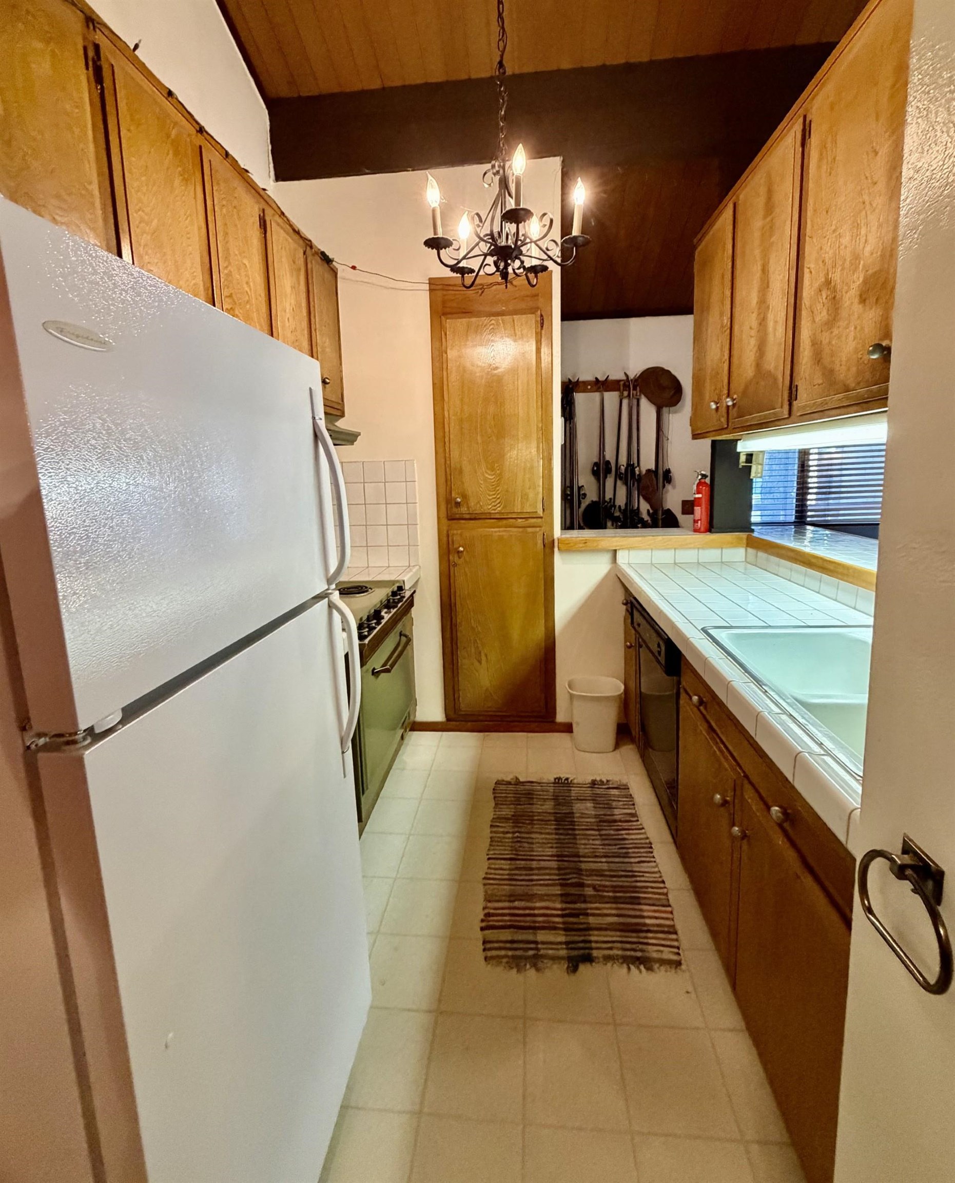 165 Old Mammoth Road, Unit 105 Mammoth Lakes, CA 93546 - Photo 14 of 17 a kitchen with refrigerator a stove and cabinets