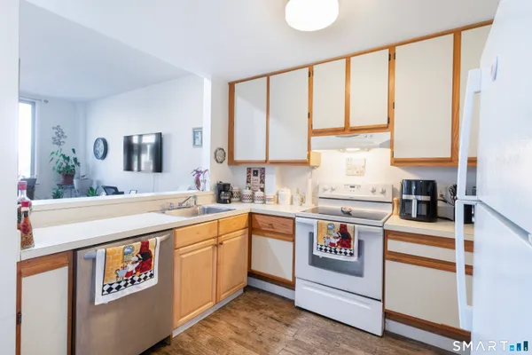 a kitchen with a stove a sink and white cabinets
