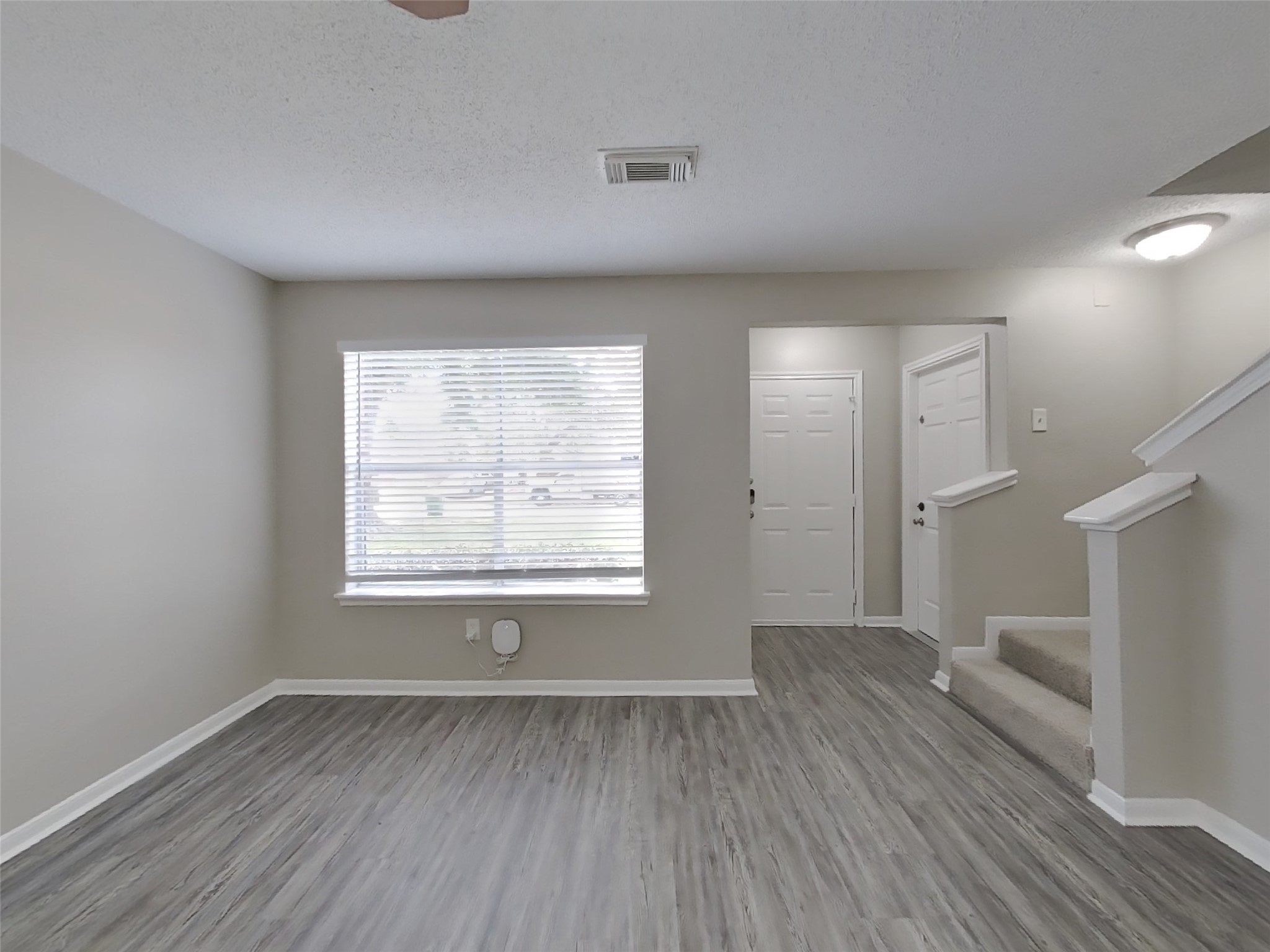 3210 Kelling Street Houston, TX 77045 - Photo 2 of 16 a view of an empty room with wooden floor and a window