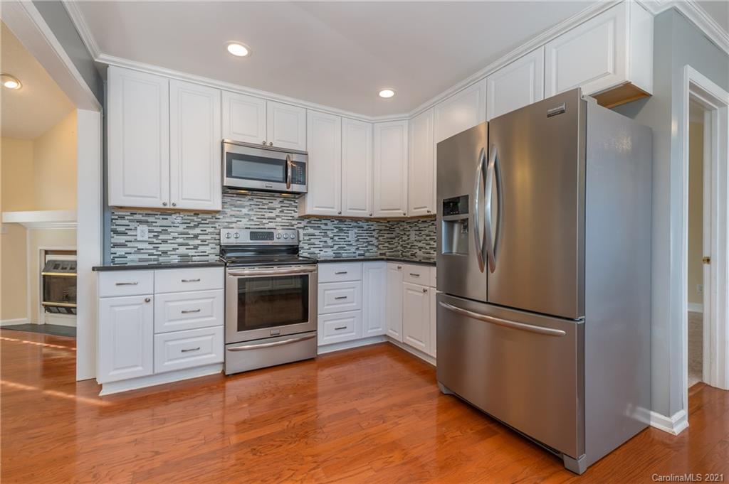 215 Orchard Grove Road, Unit 22 Campobello, SC 29322 - Photo 11 of 35 a kitchen with granite countertop stainless steel appliances a refrigerator a stove a microwave and cabinets