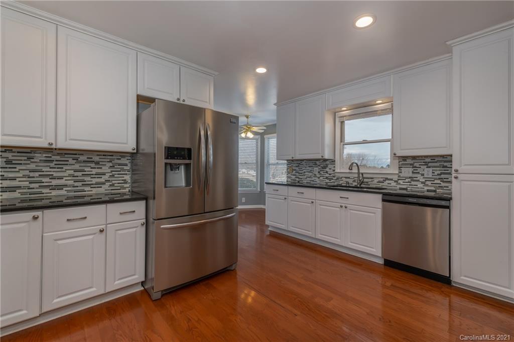 215 Orchard Grove Road, Unit 22 Campobello, SC 29322 - Photo 12 of 35 a kitchen with granite countertop stainless steel appliances a refrigerator and cabinets