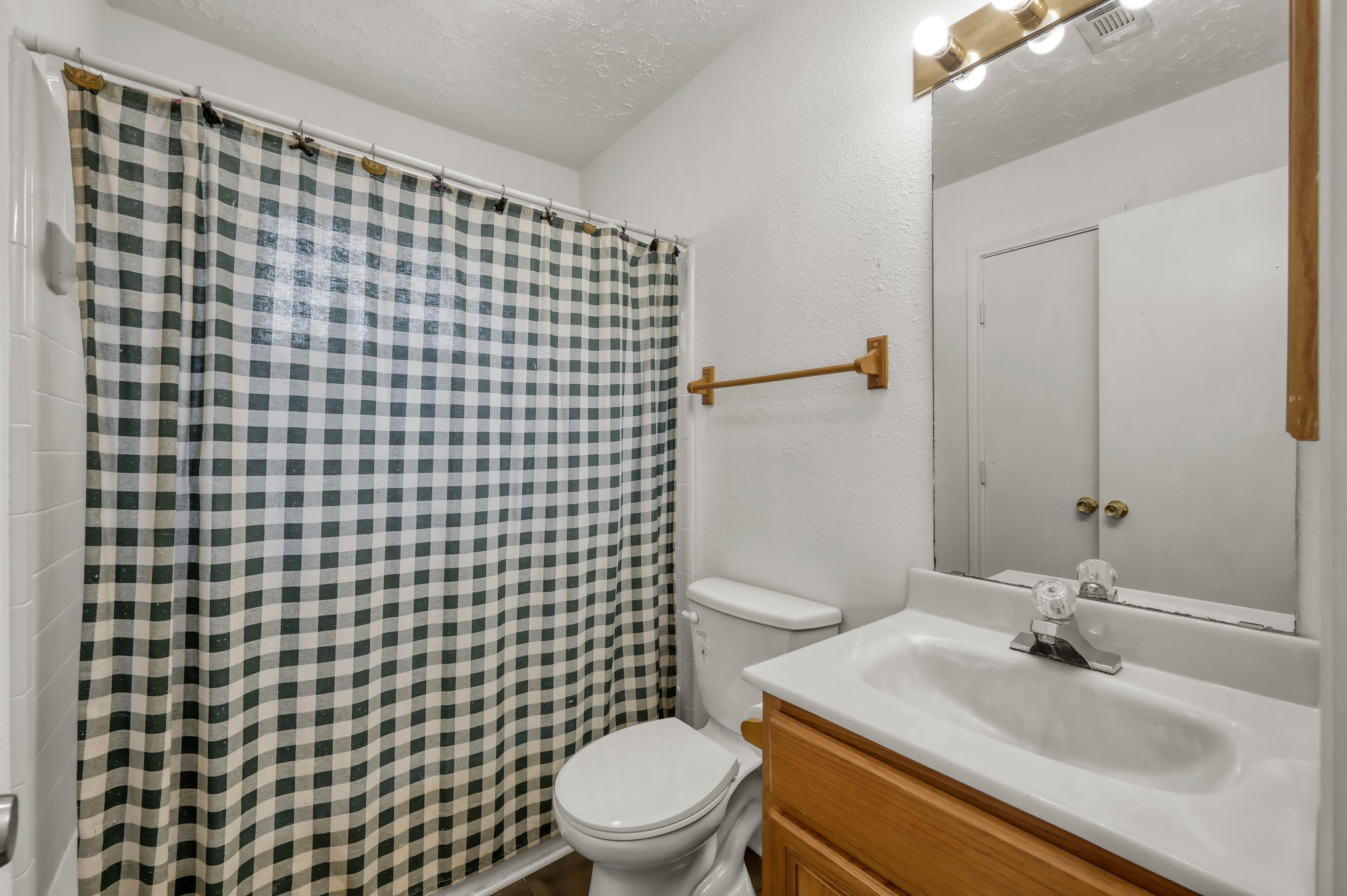 4314 Enchantedgate Drive Spring, TX 77373 - Photo 31 of 47 Guest bathroom features a white vanity with a sink, a mirror with overhead lighting. The walls are painted white, providing a clean and simple look.