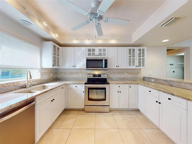 a view of a kitchen with granite countertop a white cabinets