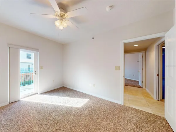 a view of an empty room and chandelier fan