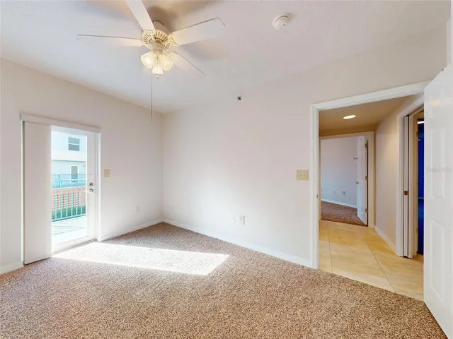 a view of an empty room and chandelier fan