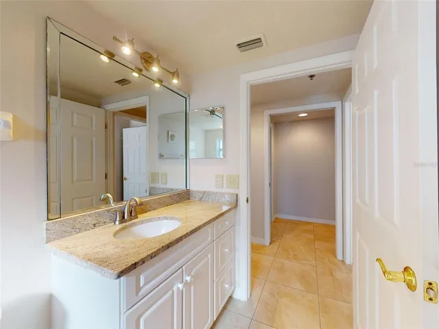 an empty room with a chandelier fan and windows