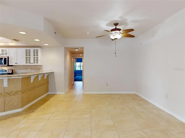 a view of kitchen with stainless steel appliances granite countertop a stove a sink a refrigerator with white cabinets and granite countertops