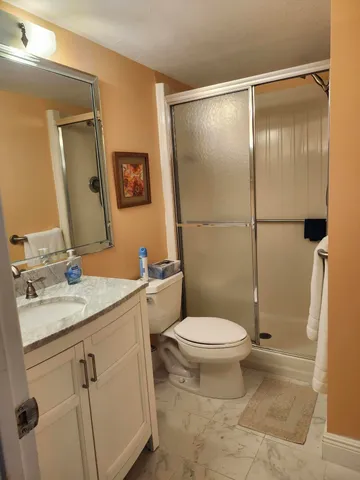 a bathroom with a granite countertop sink toilet and shower
