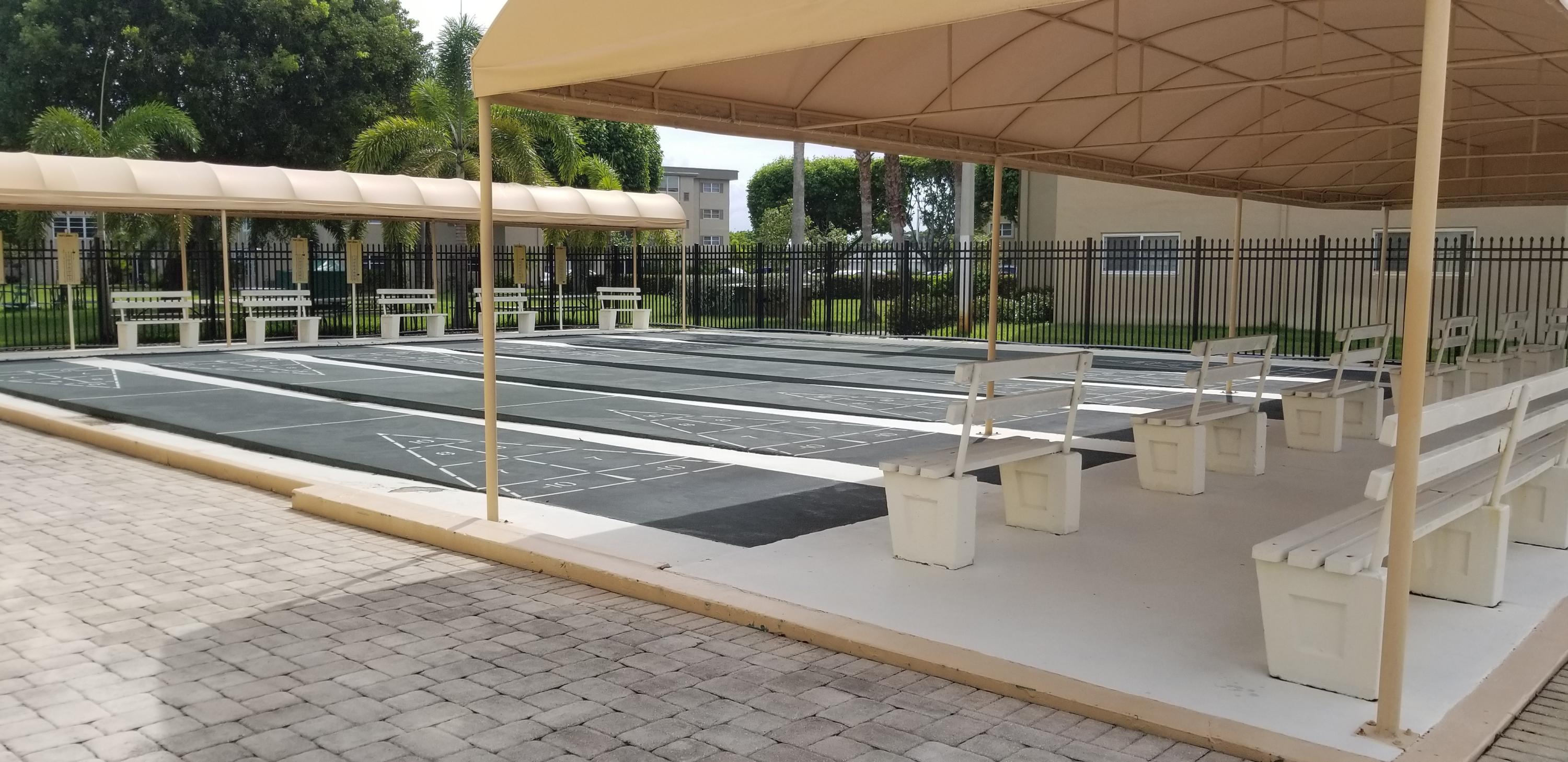 330 Northeast 26th Avenue, Unit 212 Boynton Beach, FL 33435 - Photo 23 of 31 a view of a patio with a table and chairs under an umbrella
