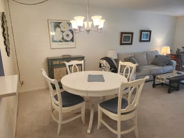 a view of a dining room with furniture and a chandelier fan