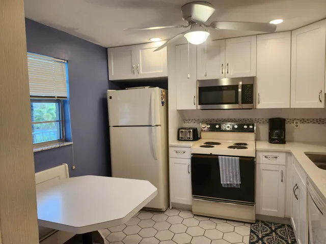 a kitchen with stainless steel appliances a stove refrigerator sink and cabinets
