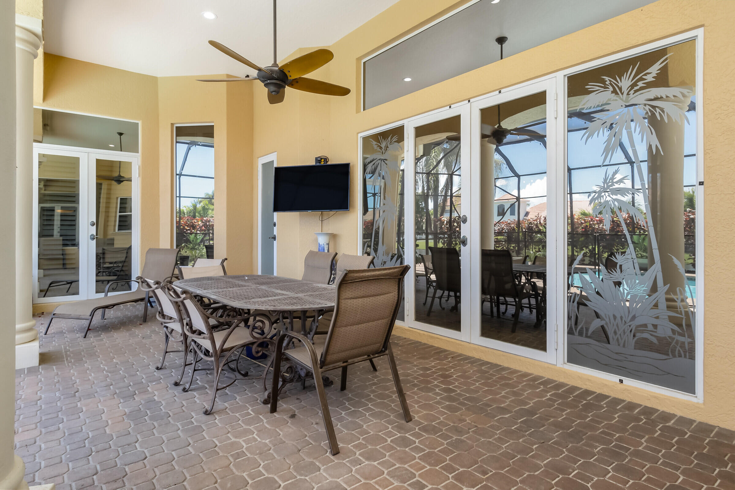 335 Normandy Drive Indialantic, FL 32903 - Photo 23 of 55 a dining room with furniture a flat screen tv and a floor to ceiling window
