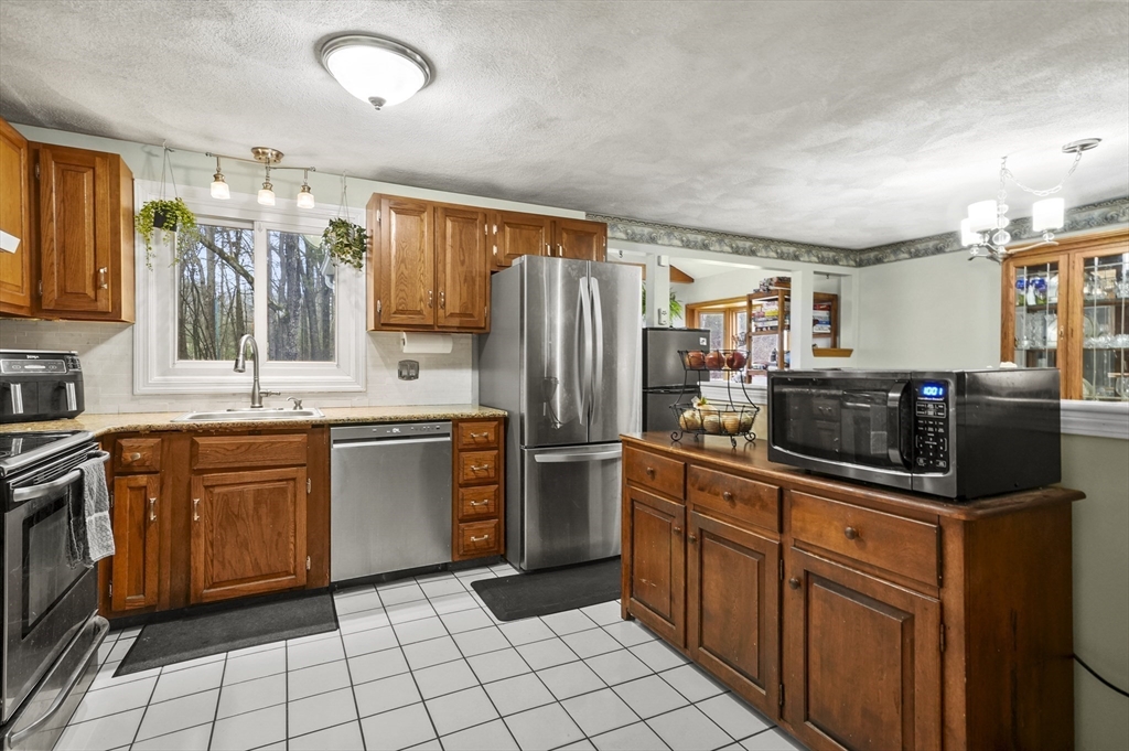 33 Frost Road Derry, NH 03038 - Photo 12 of 30 a kitchen with stainless steel appliances granite countertop a refrigerator and a stove top oven